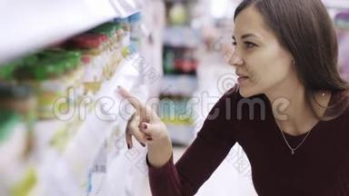 女人的肖像是在超市里寻找价格标签和产品